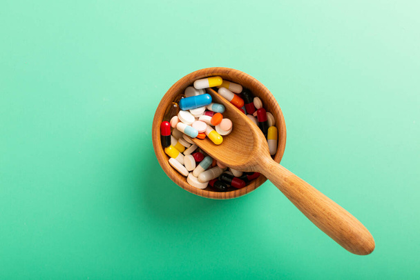 pills in a wooden container with a spoon. High quality photo - Φωτογραφία, εικόνα