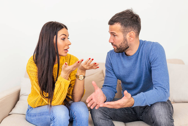 Young Couple Have Disagreement at Home. Quarrel in Young Family. Sad Woman. Divorce Concept. Upset Husband. Relationship between People Concept. Conversation in the livingroom - Photo, Image