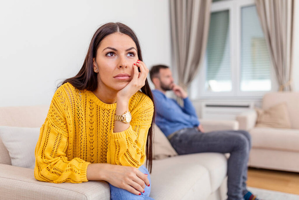 Sad couple not talking to each other after quarrel. Pensive upset woman feeling offended, thinking over problems in relationships, anxious about future, upset man sitting in the background - Photo, Image