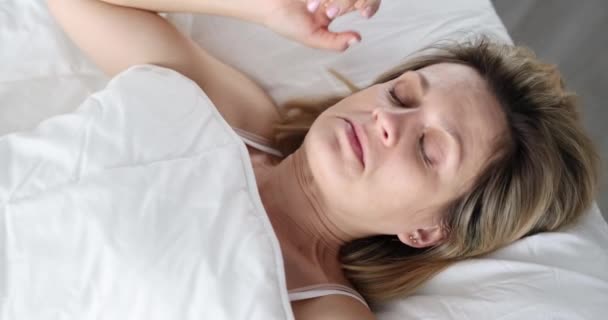 Uma mulher acorda e olha de surpresa sob os lençóis, de perto. Sangramento em um sonho, estresse de manhã - Filmagem, Vídeo