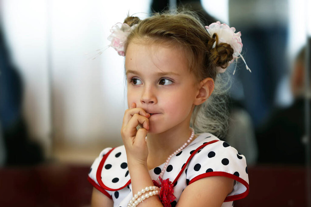 Little girl bites her nails. - Foto, Bild