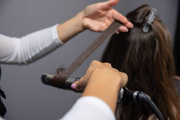hairdresser makes a haircut in the salon - Fotoğraf, Görsel