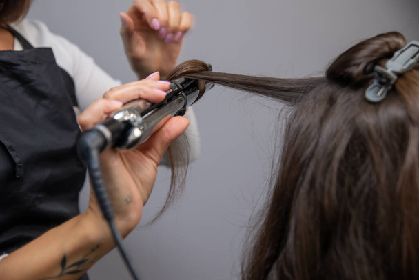 hairdresser cuts hair salon, close up - Фото, изображение