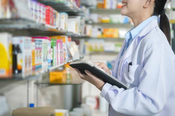 A Portrait of female pharmacist using tablet in a modern pharmacy drugstore. - Foto, Imagem