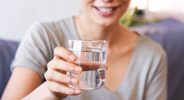 jonge vrouw drinken van een glas water - Foto, afbeelding