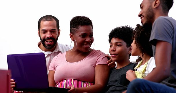Szczęśliwa rodzinna wideokonferencja na laptopie. międzyrasowych rodziców i mieszane dzieci rasy machając - Zdjęcie, obraz