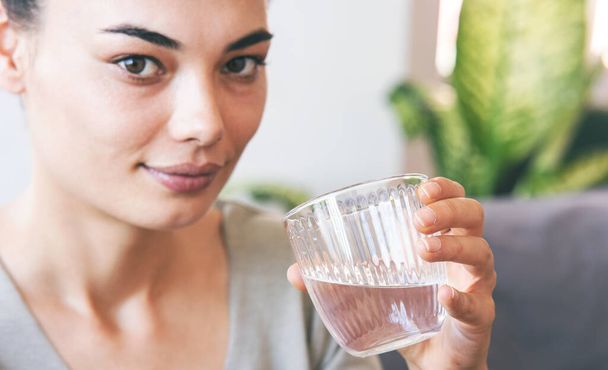 jonge vrouw drinken van een glas water - Foto, afbeelding