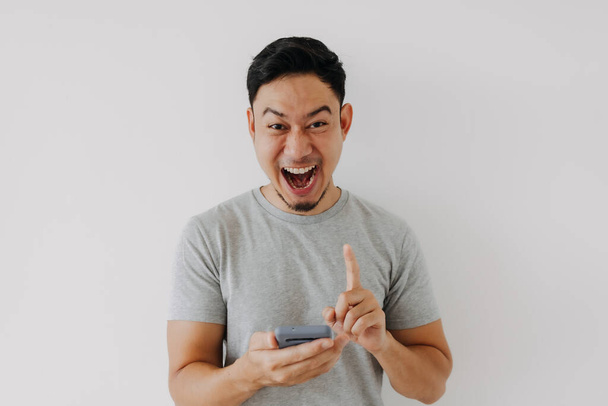 Wow y sorpresa cara asiático hombre uso smartphone con copia espacio de anuncio. - Foto, imagen