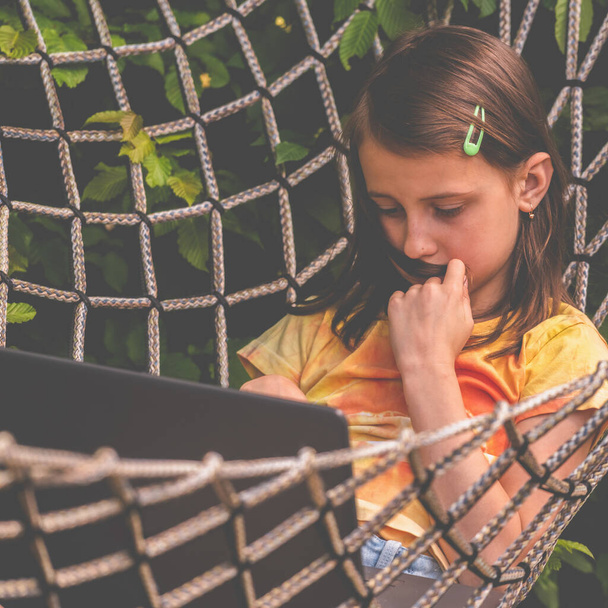 Close up young business girl lies in a hammock and working remotely with laptop. Horizontal image. - Φωτογραφία, εικόνα