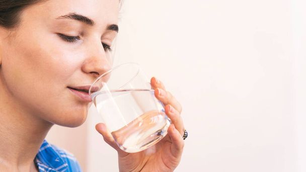 Vrouw die thuis een vers glas water drinkt - Foto, afbeelding