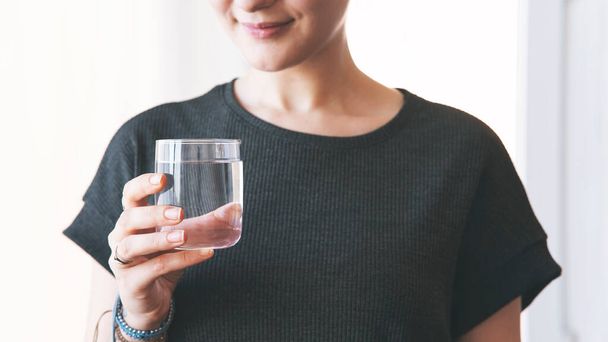  Woman drinking a fresh glass of water at home - Foto, Imagen