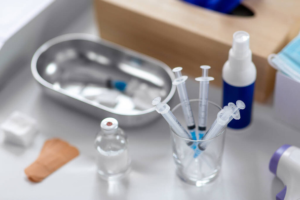 medicine and healthcare concept - close up of syringes, drug in jar and other stuff on table at hospital - Fotó, kép