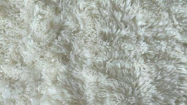 Bovenaanzicht van pastelwitte pluizige deken. Natuurlijke abstracte achtergrond. - Video