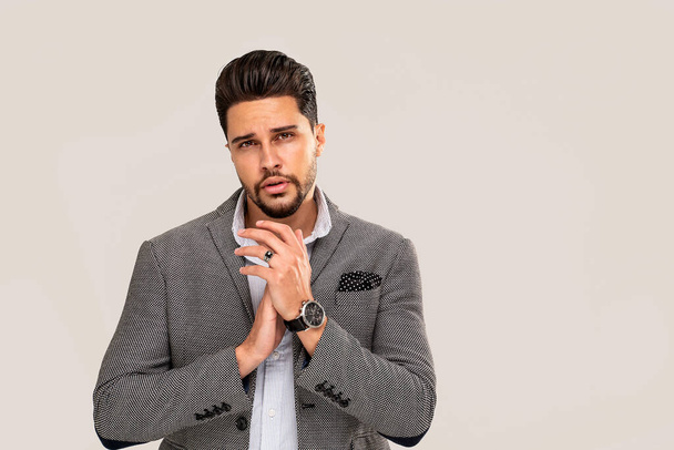 Young handsome businessman in elegant fashionable clothes looking at the camera. Portrait of bearded elegant man. Gray studio backgroun - Fotografie, Obrázek