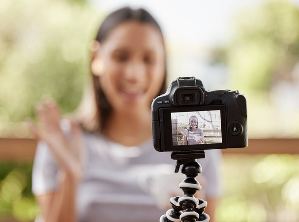 молода жінка сидить на вулиці і використовує камеру для відеоблогу
. - Фото, зображення