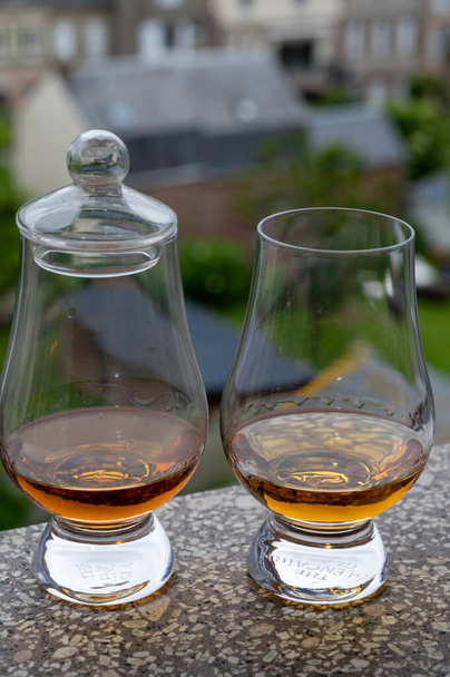 Dwa dramaty szkockiej whisky z widokiem na stare domy na tle, degustacja whisky w Edynburgu, Szkocja - Zdjęcie, obraz