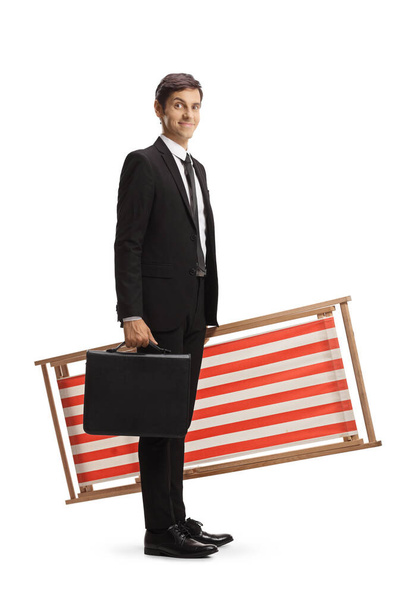 Businessman carrying a beach chair and a briefcase isolated on white background - Fotografie, Obrázek