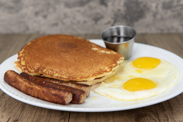 Standard American breakfast consisting of pancakes, fried eggs, and sausage will ensure that the belly will be full. - Photo, Image