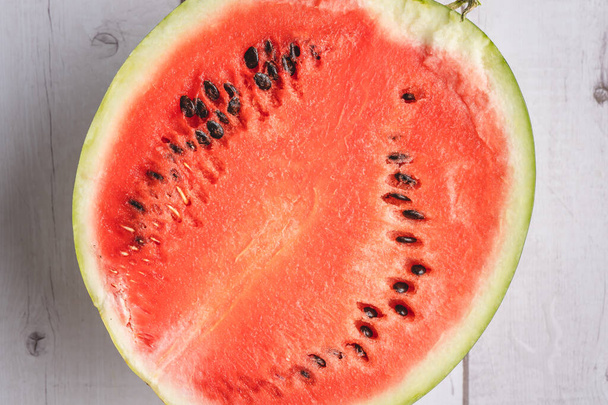 Half of watermelon sliced on the wooden background table copy space - 写真・画像