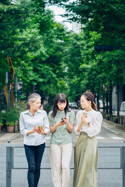 mujeres asiáticas de varias edades utilizando teléfonos inteligentes - Foto, imagen