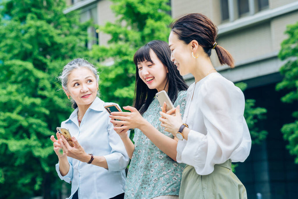 femmes asiatiques de différents âges à l'aide de smartphones - Photo, image