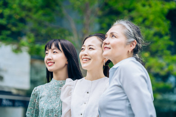Three women of different generations outdoors - 写真・画像