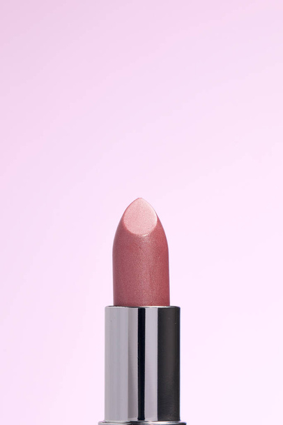 Lipctick bullet macro.  Close up of lipstick in silver packaging on pink background. - Foto, immagini