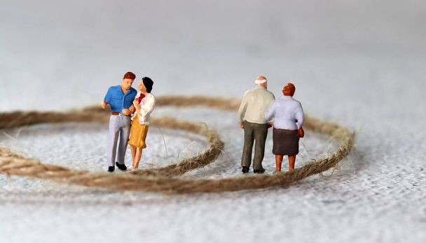 Rope and miniature people. The concept of generational conflict. - Foto, Imagen