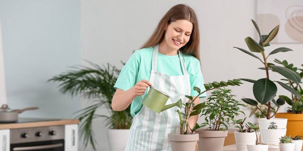 Fiatal nő öntözés szobanövények otthon - Fotó, kép