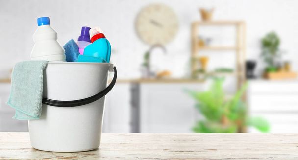 Set of cleaning supplies on wooden table in kitchen - Photo, Image