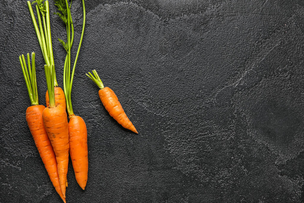 Fresh ripe carrot on dark background - Fotó, kép