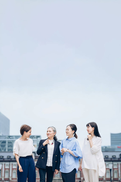 four business women lined up with smiles outdoors - Foto, afbeelding