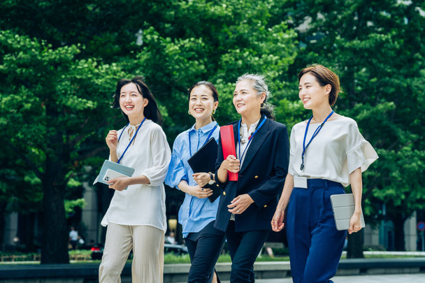 Деловые женщины разных возрастов прогуливаются по деловому району - Фото, изображение