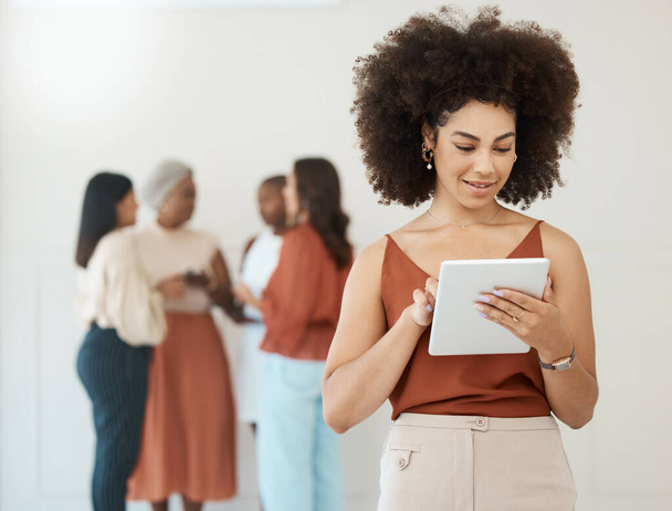 Ritratto di una giovane donna d'affari felice di razza mista con un riccio afro holding e utilizzando un tablet digitale in un ufficio al lavoro. Uomo d'affari ispanico sorridente durante l'utilizzo dei social media su un digitale - Foto, immagini