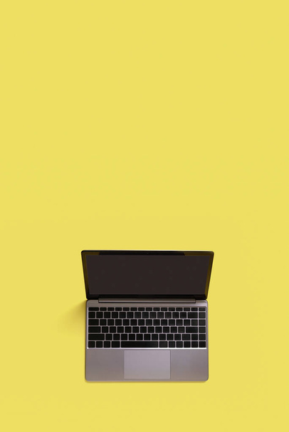 Вид зверху на сучасний ноутбук ізольований на жовтому тлі. Копіювати простір
. - Фото, зображення