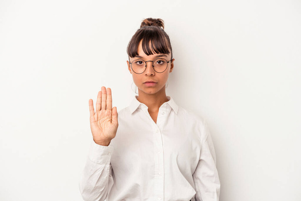 Nuori sekarotuinen liiketoiminnan nainen eristyksissä valkoisella taustalla seisoo ojennetulla kädellä osoittaa stop-merkki, estää sinua. - Valokuva, kuva