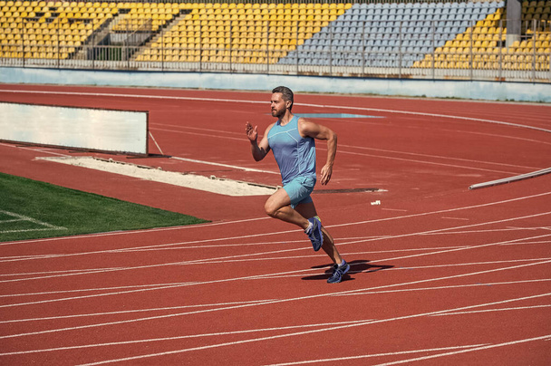 energetic and sporty. marathon speed energy. muscular man in motion. athletic man compete in sprint. be the first. sport healthy lifestyle. fitness training outdoor. runner run fast on running track. - Φωτογραφία, εικόνα