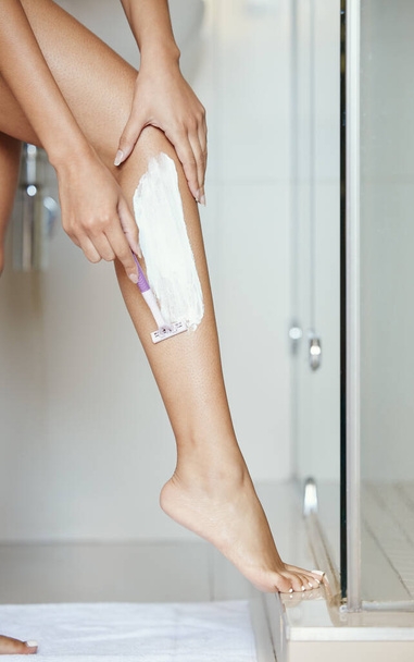 an unrecognizable woman shaving her legs at home. - Φωτογραφία, εικόνα