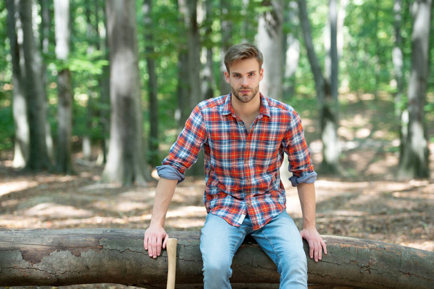 young handsome man in checkered shirt sit outdoor. - 写真・画像