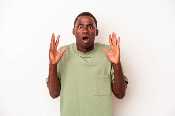 Junge afrikanisch-amerikanische Mann isoliert auf weißem Hintergrund überrascht und schockiert. - Foto, Bild