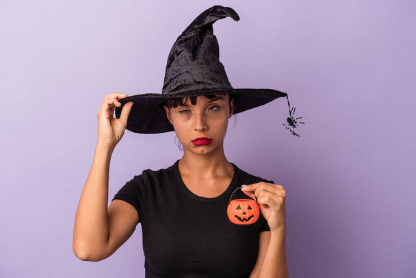 Young mixed race woman disguised as a witch isolated on purple background  being shocked, she has remembered important meeting. - Photo, Image