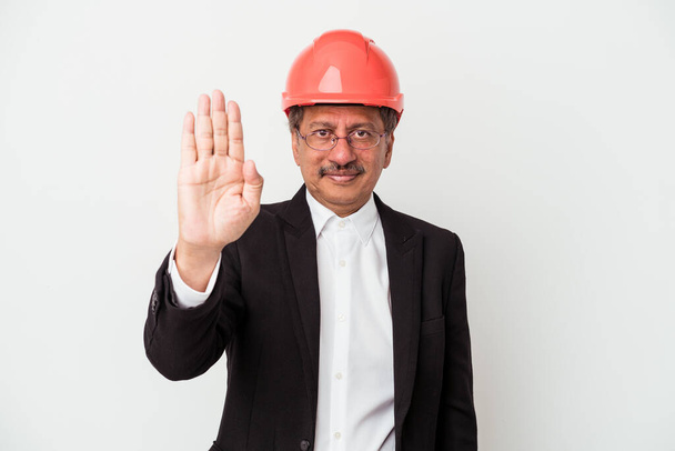 Індіанський архітектор середнього віку, ізольований на білому фоні, стоїть з витягнутою рукою і показує знак "Стоп", запобігаючи вам. - Фото, зображення