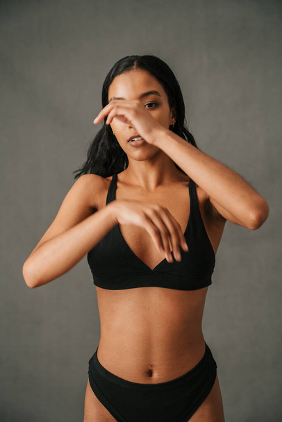 Slender Multiethnic female in her underwear waving her arms standing in the studio . High quality photo - Φωτογραφία, εικόνα