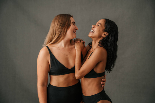 Two friends just having lots of fun laughing and smiling while posing in the studio. High quality photo - Fotó, kép