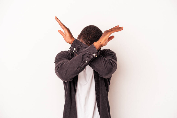Genç Afrikalı Amerikalı adam beyaz arka planda izole edilmiş iki kolu çapraz tutuyor, inkar kavramı. - Fotoğraf, Görsel