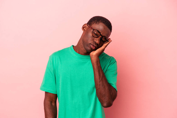Young African American man isolated on pink background who is bored, fatigued and need a relax day. - Photo, Image