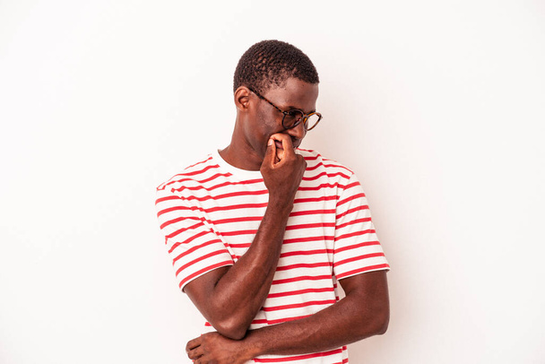 Νεαρός Αφροαμερικάνος απομονωμένος σε λευκό φόντο χαλαρός σκεπτόμενος κάτι κοιτάζοντας ένα χώρο αντιγραφής. - Φωτογραφία, εικόνα
