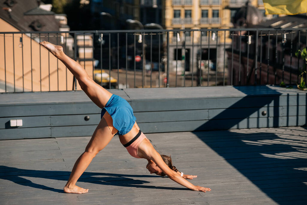 Mladá žena cvičí jógu na střeše - Fotografie, Obrázek