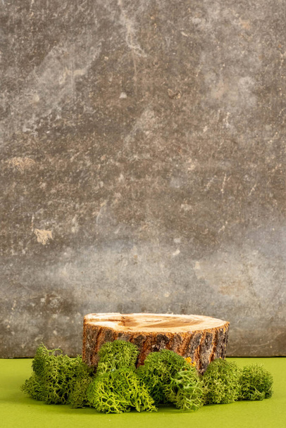 Holzpodest oder Schauständer mit grünem Moos auf grauem Hintergrund. Stillleben zur Produktpräsentation. Kopierraum - Foto, Bild