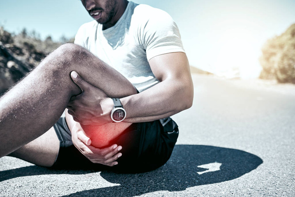 Closeup fit mixed race man holding his leg in pain while exercising outdoors. Unrecognizable male athlete suffering with a muscle hamstring injury highlighted by cgi. You can get hurt during a workout - Photo, Image